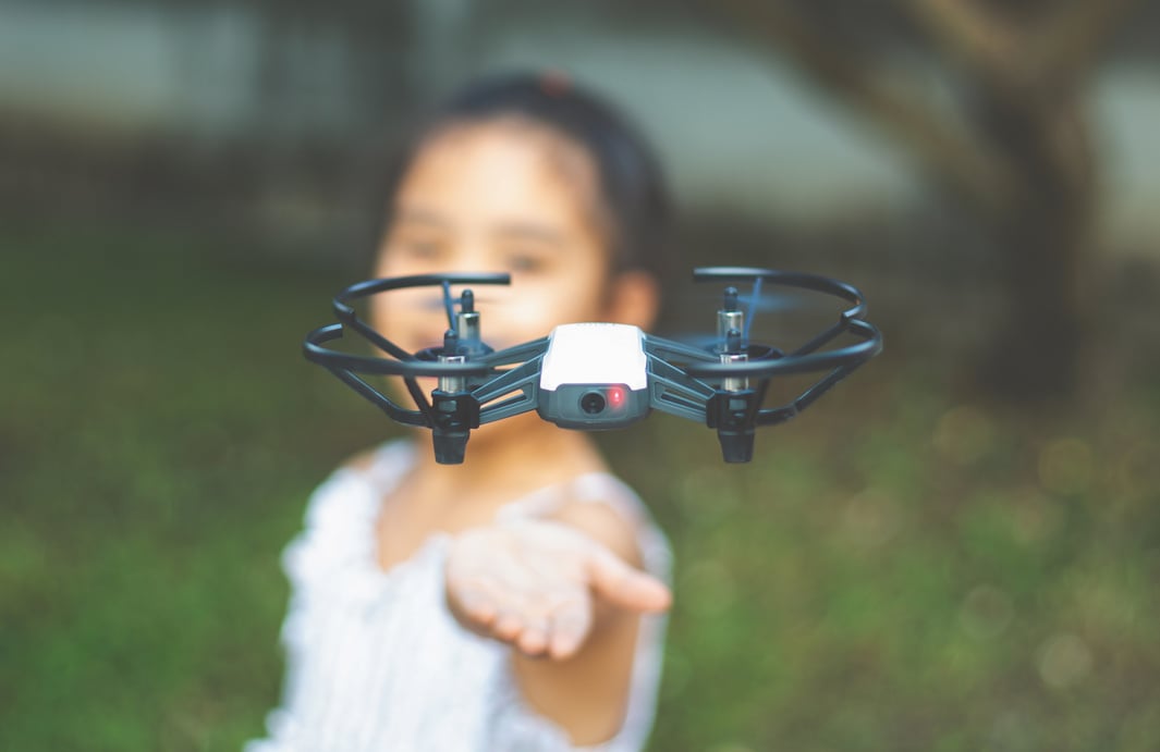 Child playing with drone outdoors at summer day